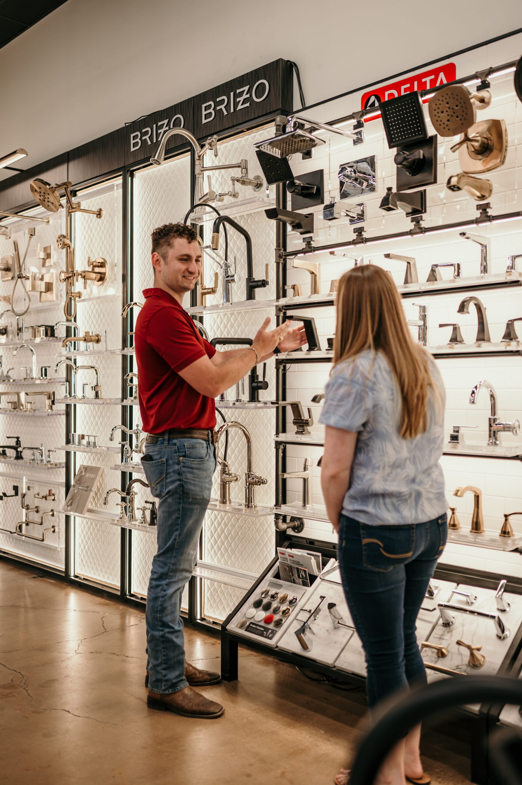 Smiling teammate assisting a contractor at a plumbing supply counter